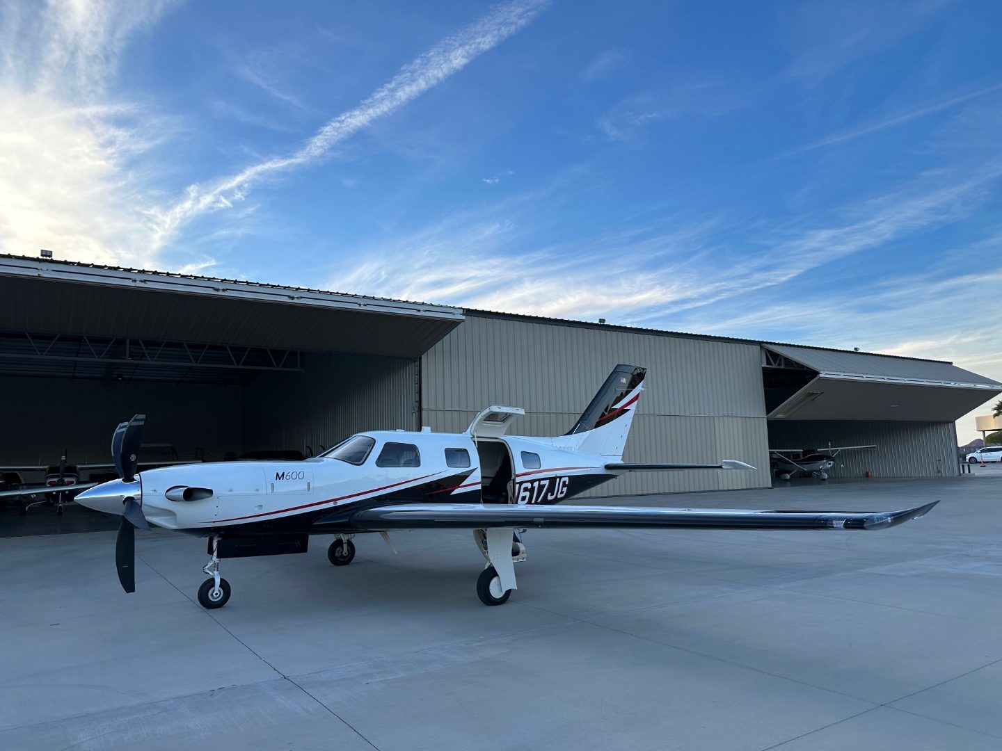 M600 turboprop parked outside an open hangar at Lake Havasu City Airport at golden hour