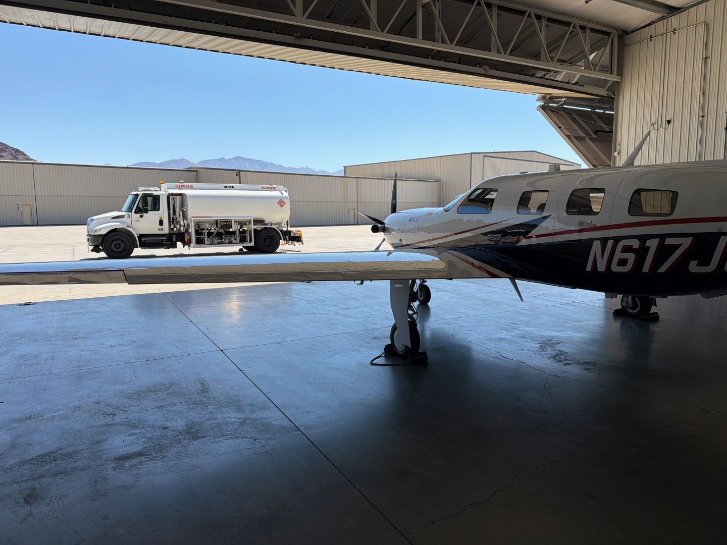 Aircraft wing and fuel truck on the ramp at KHII with mountains in the background